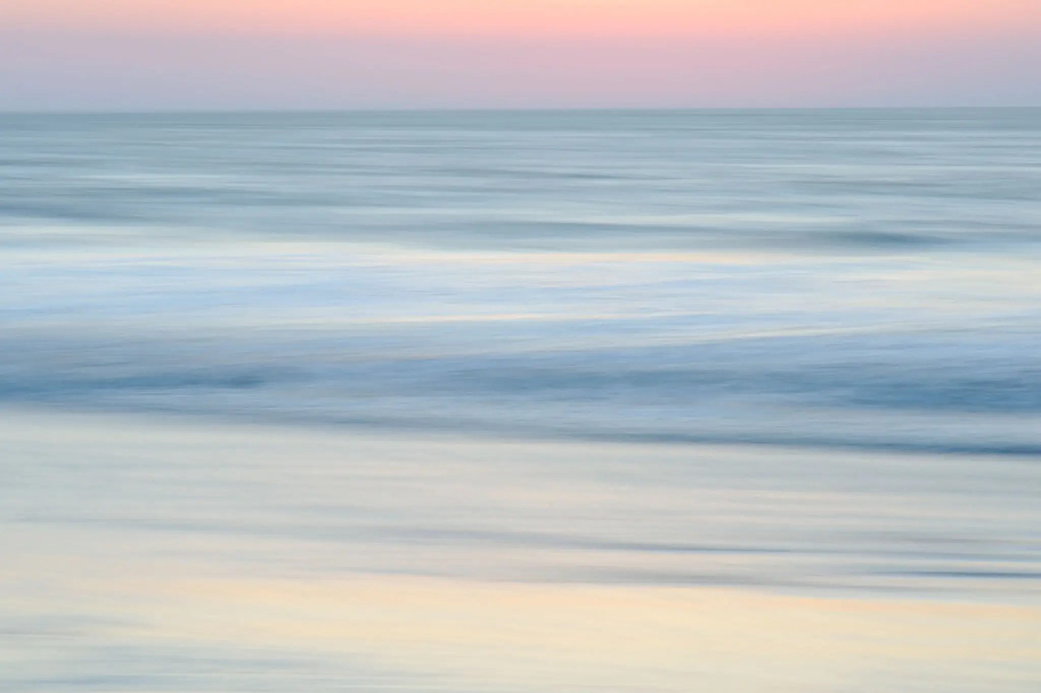 Colors of ocean at sunrise (long exposure with panning)